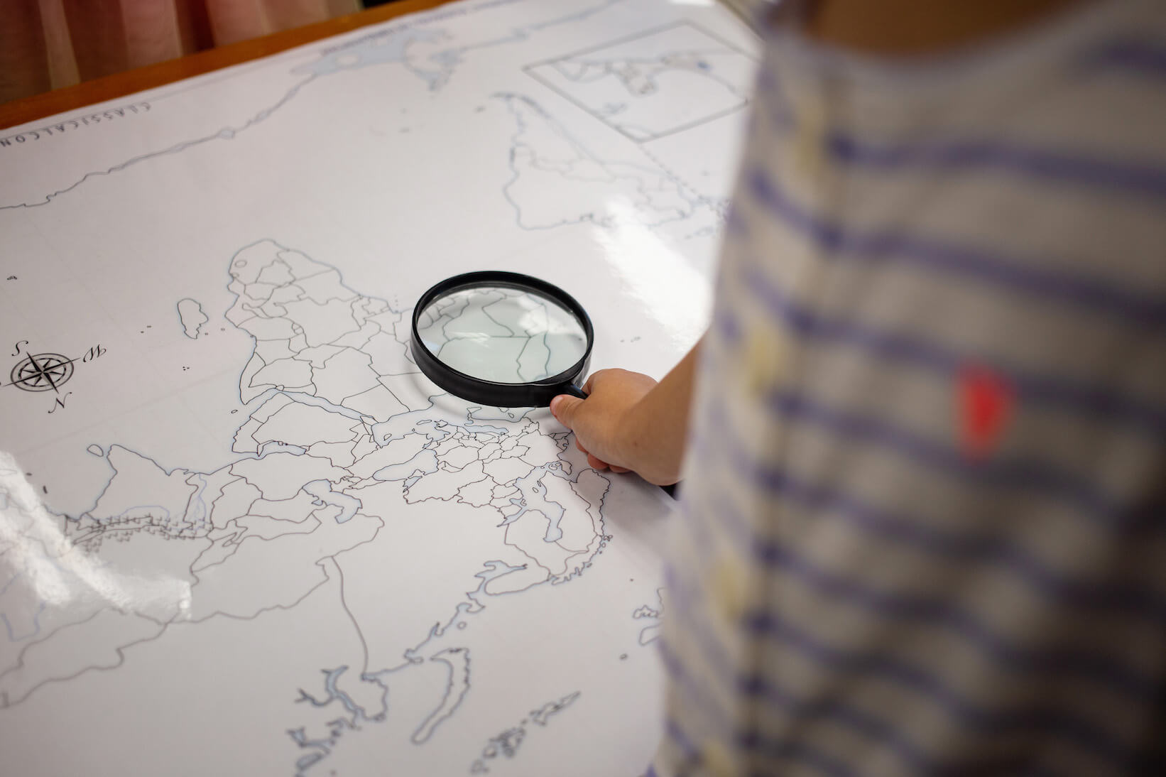 A boy studies a map; a classical math curriculum inspires curiosity.